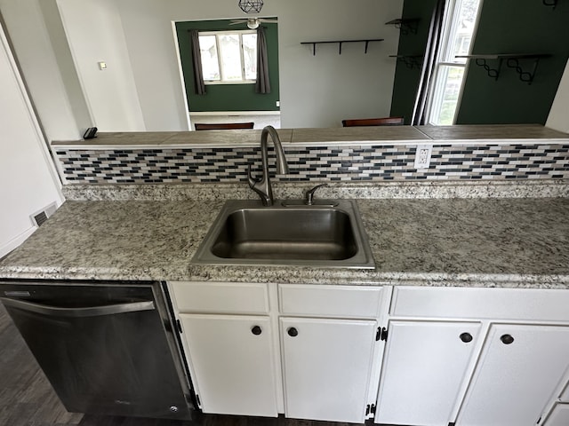 kitchen with dishwasher, a sink, white cabinets, and plenty of natural light