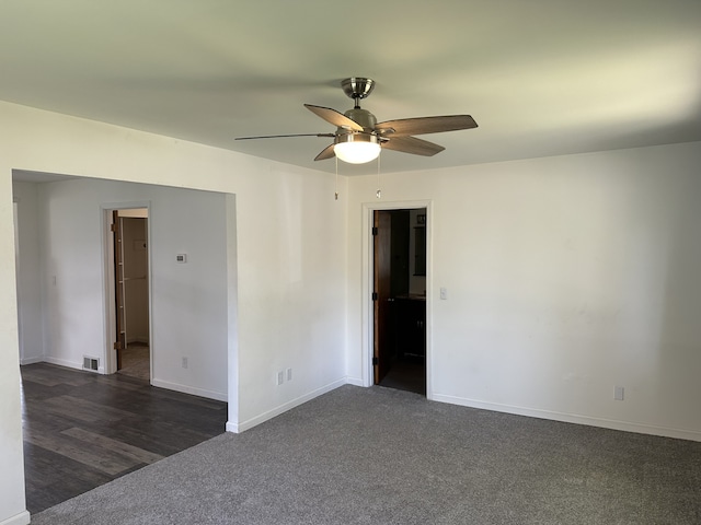 carpeted empty room with a ceiling fan and baseboards