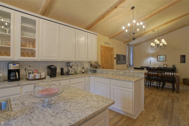 6961 Mt Highway 200, Plains, MT 59859 - kitchen featuring a chandelier, white cabinets, light wood-type flooring, backsplash, and a peninsula