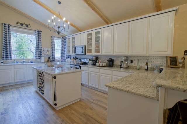 6961 Mt Highway 200, Plains, MT 59859 - kitchen with stainless steel appliances, a sink, decorative backsplash, a peninsula, and a chandelier
