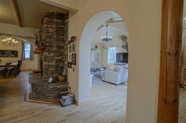 6961 Mt Highway 200, Plains, MT 59859 - hallway featuring a chandelier, arched walkways, wood finished floors, and beamed ceiling