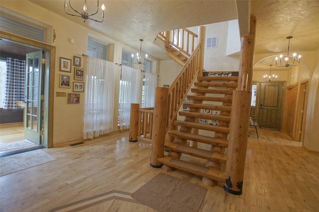6961 Mt Highway 200, Plains, MT 59859 - staircase with a chandelier, wood finished floors, baseboards, and a textured ceiling