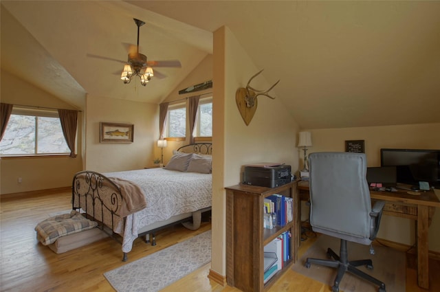 6961 Mt Highway 200, Plains, MT 59859 - bedroom featuring lofted ceiling, multiple windows, an office area, wood finished floors, and a ceiling fan