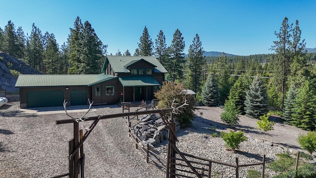 6961 Mt Highway 200, Plains, MT 59859 - rustic home featuring a forest view, an attached garage, driveway, and metal roof