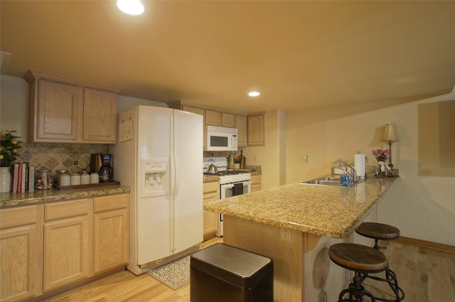 6961 Mt Highway 200, Plains, MT 59859 - kitchen featuring white appliances, light wood-style floors, a peninsula, a kitchen bar, and recessed lighting