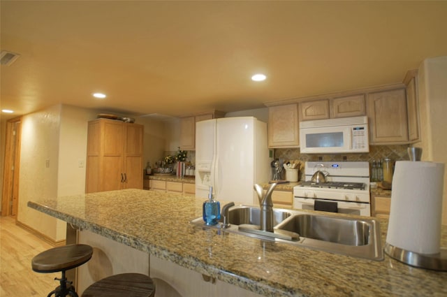 6961 Mt Highway 200, Plains, MT 59859 - kitchen with white appliances, a kitchen breakfast bar, recessed lighting, tasteful backsplash, and a sink