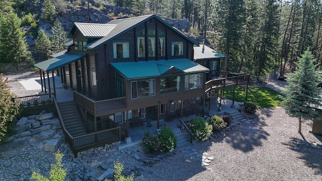 6961 Mt Highway 200, Plains, MT 59859 - rear view of house featuring stairs, a patio, metal roof, a wooden deck, and a forest view