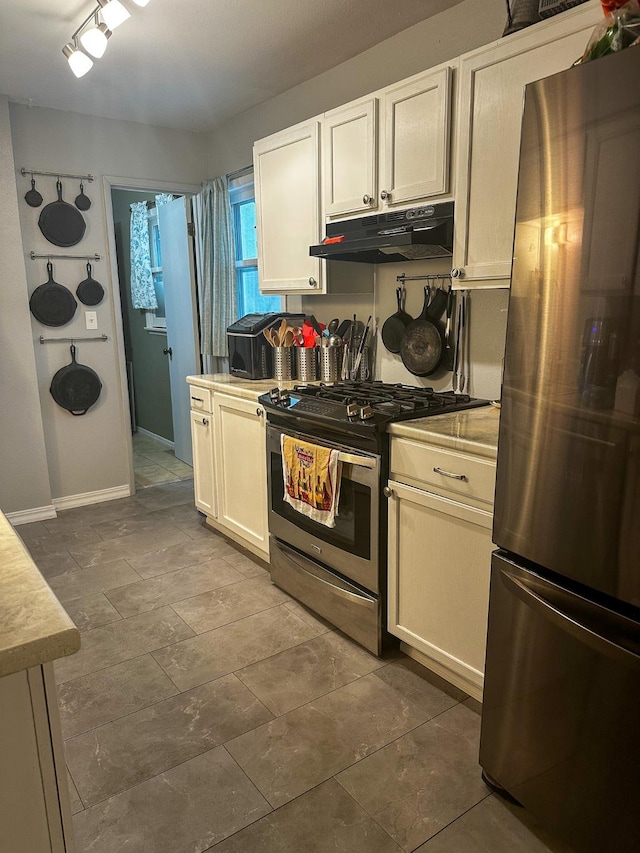 325 River Dr, Lolo, MT 59847 - kitchen with appliances with stainless steel finishes, under cabinet range hood, light countertops, and white cabinetry