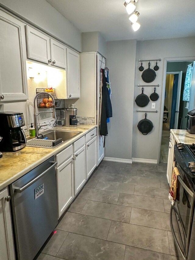 325 River Dr, Lolo, MT 59847 - kitchen featuring dishwasher, gas stove, white cabinetry, light countertops, and dark tile patterned floors