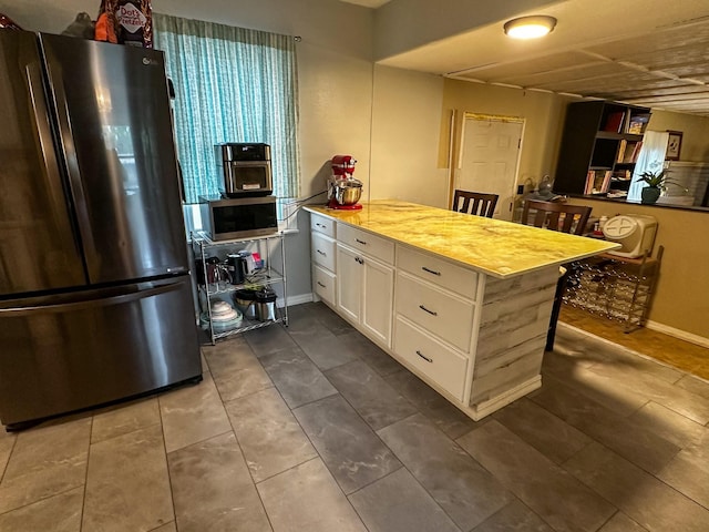 325 River Dr, Lolo, MT 59847 - kitchen with appliances with stainless steel finishes, a peninsula, white cabinets, and baseboards