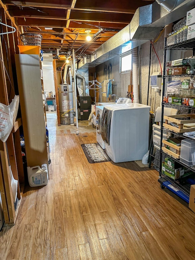 325 River Dr, Lolo, MT 59847 - below grade area featuring water heater, separate washer and dryer, wood finished floors, and heating unit