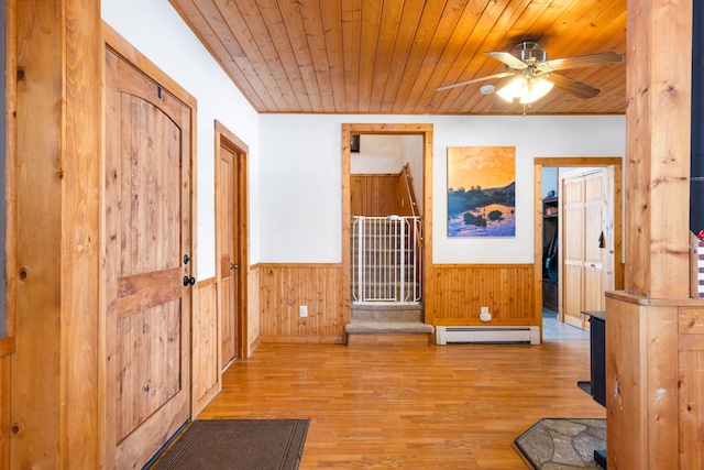 412 Mill St, Sheridan, MT 59749 - entryway with a baseboard heating unit, wood ceiling, a wainscoted wall, a ceiling fan, and wood finished floors