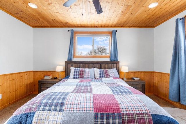 412 Mill St, Sheridan, MT 59749 - carpeted bedroom featuring wooden walls, a wainscoted wall, crown molding, recessed lighting, and ceiling fan