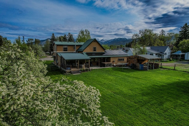 412 Mill St, Sheridan, MT 59749 - rear view of house featuring a mountain view, metal roof, an outdoor structure, and a patio