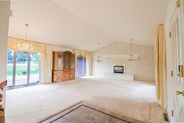 6 Cedar Lake Dr, Butte, MT 59701 - unfurnished living room featuring carpet flooring, brick wall, vaulted ceiling, a chandelier, and a brick fireplace