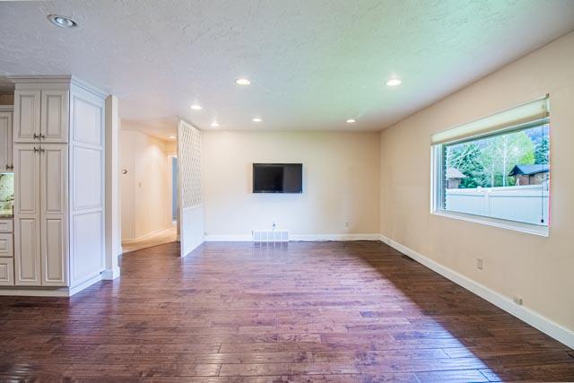 6 Cedar Lake Dr, Butte, MT 59701 - unfurnished living room featuring dark wood-style flooring, baseboards, and recessed lighting