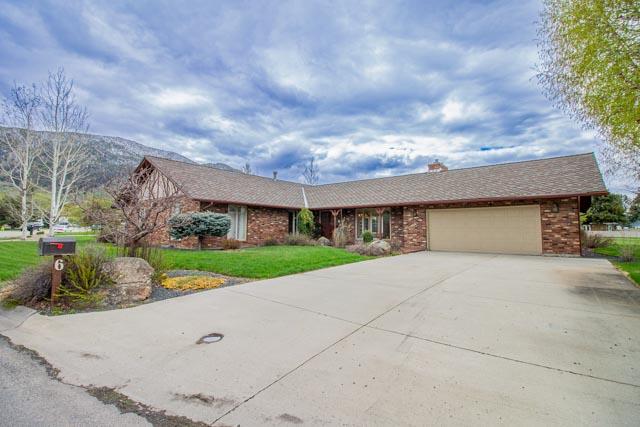 6 Cedar Lake Dr, Butte, MT 59701 - view of front facade with a garage, concrete driveway, a front lawn, and brick siding