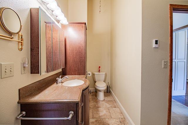6 Cedar Lake Dr, Butte, MT 59701 - bathroom with toilet, vanity, baseboards, and a textured wall