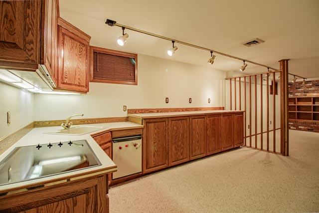 6 Cedar Lake Dr, Butte, MT 59701 - kitchen with brown cabinets, black electric stovetop, a sink, light countertops, and track lighting