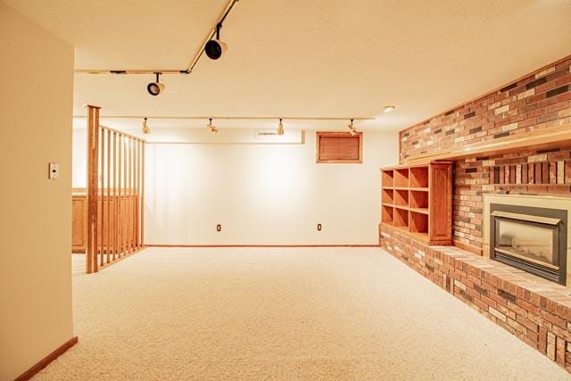 6 Cedar Lake Dr, Butte, MT 59701 - basement featuring a brick fireplace, carpet flooring, rail lighting, baseboards, and brick wall