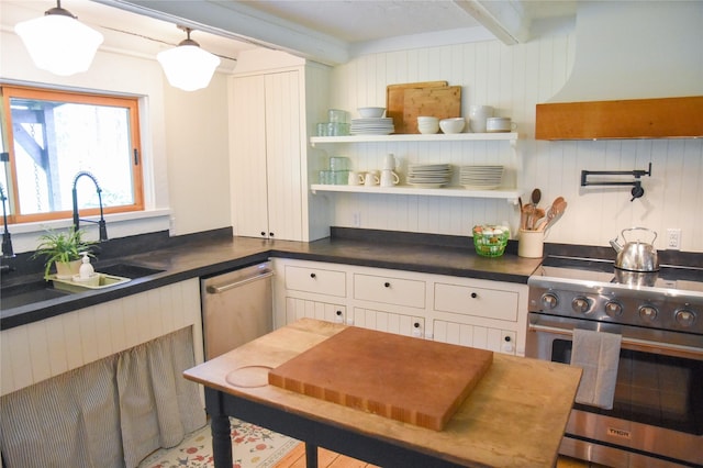 kitchen featuring high end stove, premium range hood, a sink, beamed ceiling, and dark countertops