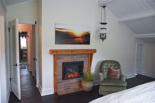 bedroom featuring dark wood finished floors, baseboards, and a brick fireplace