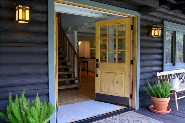 doorway to property with faux log siding