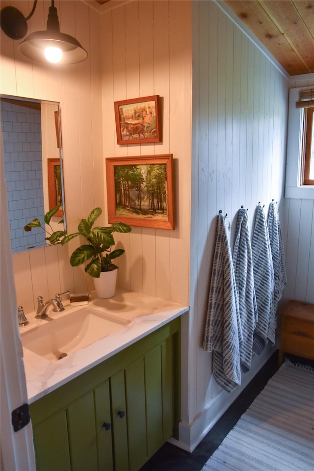 bathroom featuring vanity, wood walls, and wood ceiling