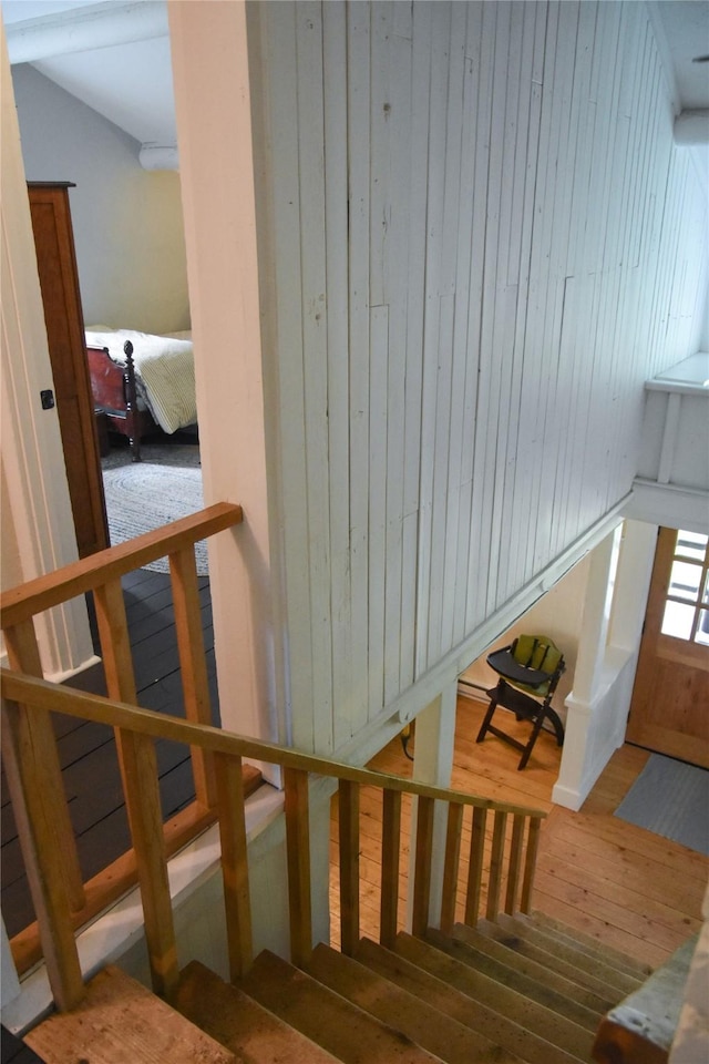 staircase featuring hardwood / wood-style floors and wood walls