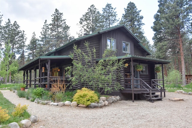 view of side of property featuring log exterior and a porch