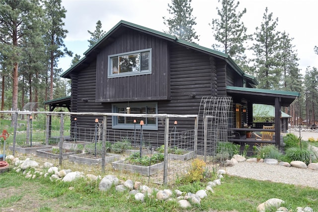 view of home's exterior featuring a vegetable garden and log exterior
