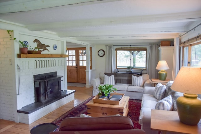 living area with light wood-style flooring and beam ceiling