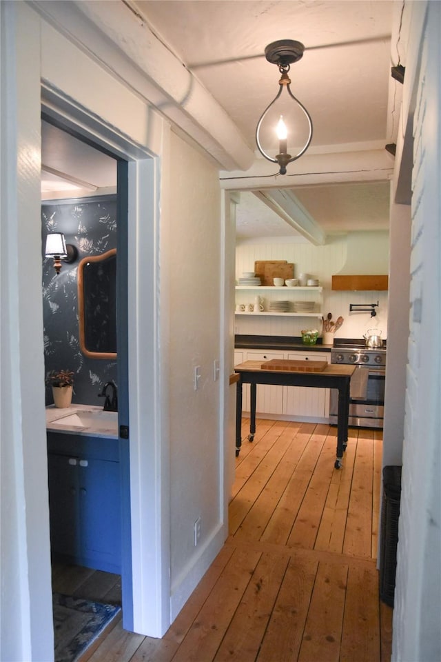 hallway featuring hardwood / wood-style floors and a sink