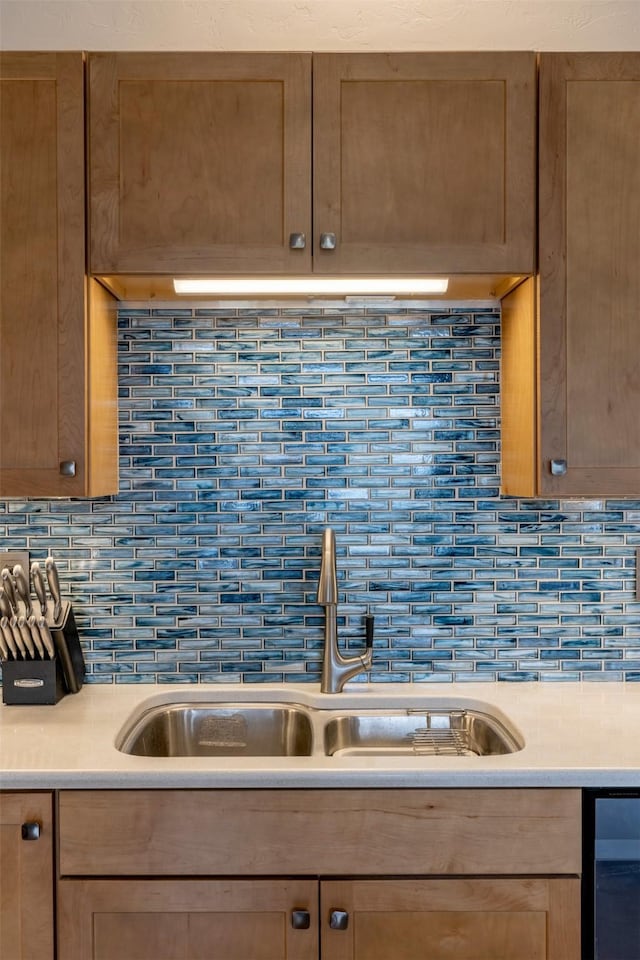 kitchen featuring backsplash, a sink, and light countertops
