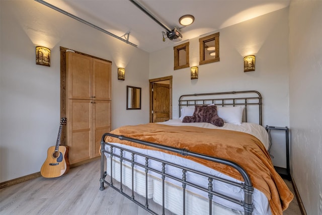 bedroom with light wood-style flooring and baseboards