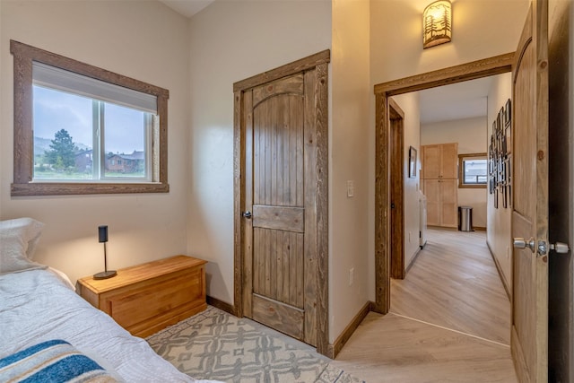 bedroom with light wood finished floors and baseboards