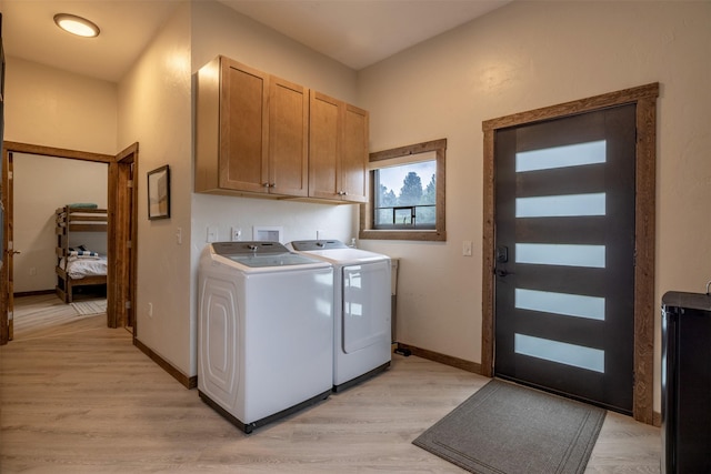 laundry room with washer and clothes dryer, cabinet space, light wood-style floors, and baseboards