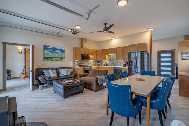 dining space featuring light wood finished floors and a ceiling fan