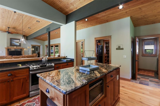 318 Mt Highway 56, Noxon, MT 59853 - kitchen featuring appliances with stainless steel finishes, a fireplace, wooden ceiling, light wood finished floors, and dark stone counters