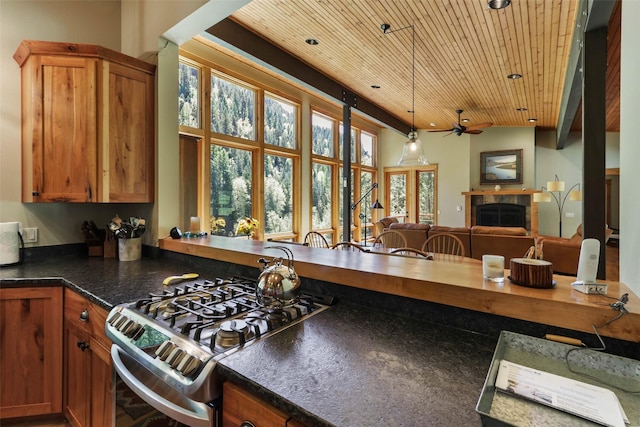 318 Mt Highway 56, Noxon, MT 59853 - kitchen with gas range, wood ceiling, a tile fireplace, a ceiling fan, and dark countertops