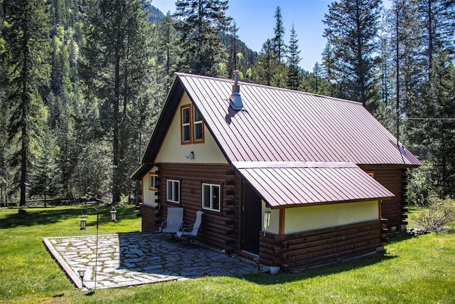 318 Mt Highway 56, Noxon, MT 59853 - view of side of property with log siding, a lawn, a patio, and a forest view