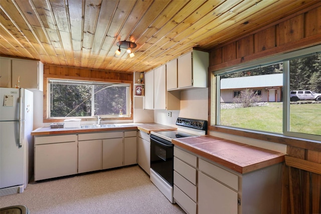 318 Mt Highway 56, Noxon, MT 59853 - kitchen featuring white appliances, wood ceiling, tile counters, a sink, and light colored carpet