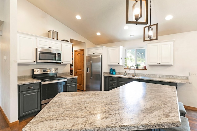 301 Bernie Rd, Alberton, MT 59820 - kitchen with appliances with stainless steel finishes, a sink, vaulted ceiling, white cabinetry, and baseboards