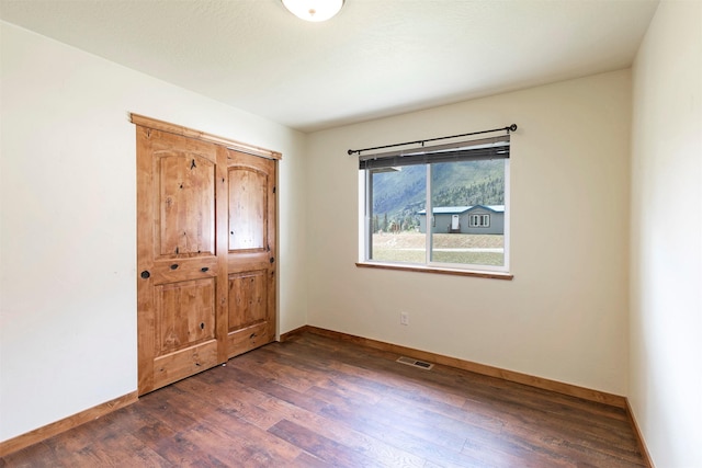 301 Bernie Rd, Alberton, MT 59820 - unfurnished bedroom featuring dark wood finished floors and baseboards