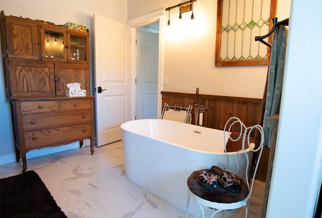 4714 Linhart Ln, Stevensville, MT 59870 - full bathroom with wainscoting, marble look tiles, a soaking tub, and wooden walls