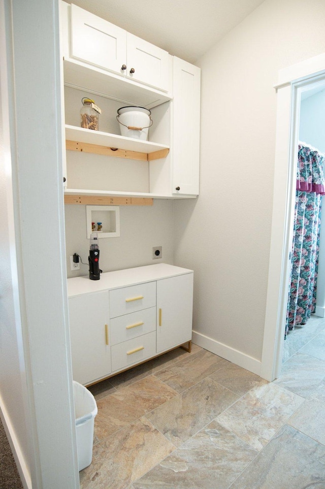 4714 Linhart Ln, Stevensville, MT 59870 - laundry area with hookup for an electric dryer, washer hookup, baseboards, cabinet space, and light stone finish floors