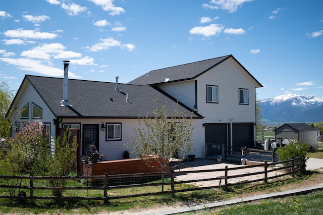 4714 Linhart Ln, Stevensville, MT 59870 - back of property featuring a garage, fence, concrete driveway, and a mountain view