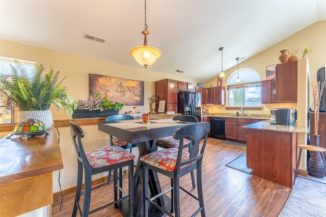dining space featuring lofted ceiling and wood finished floors