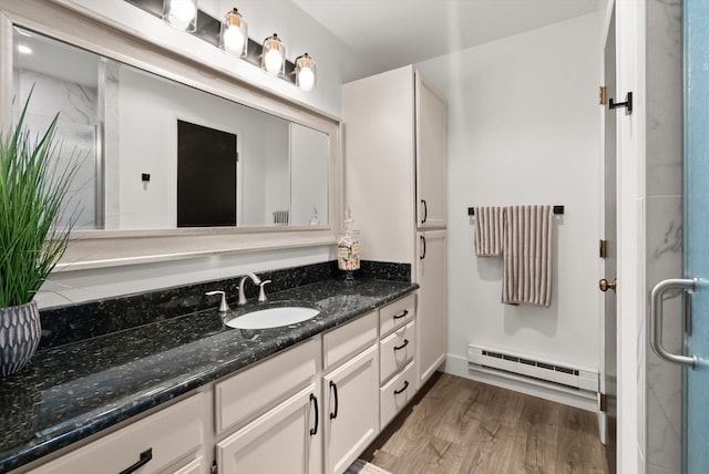 135 Sapphire Ct, Whitefish, MT 59937 - full bathroom with a baseboard heating unit, vanity, wood finished floors, and a shower with door