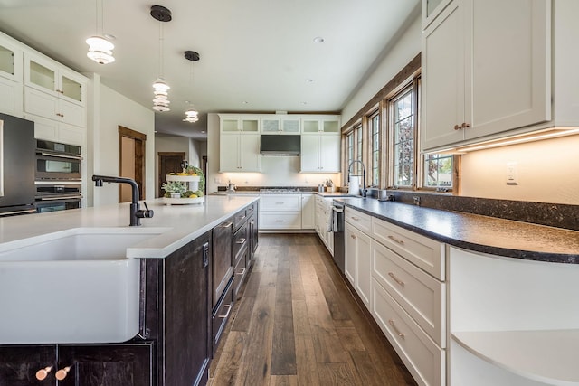 kitchen featuring dark wood finished floors, a sink, white cabinets, and gas stovetop